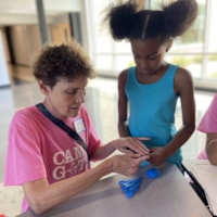A Camp GOTR coach and girl work together in the construction workshop